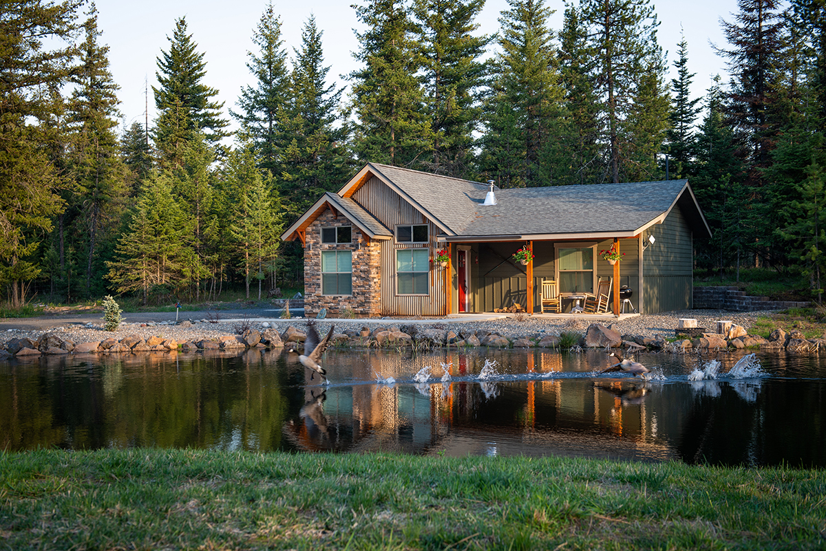 A lakeside cabin surrounded by woods.